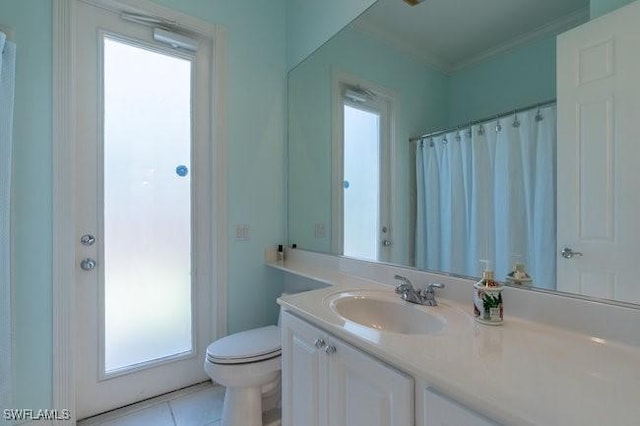 bathroom with tile patterned floors, plenty of natural light, toilet, and vanity