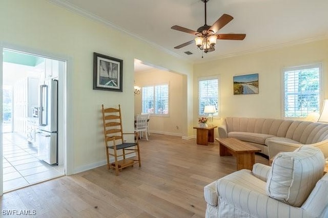 living room with plenty of natural light, crown molding, and light hardwood / wood-style flooring