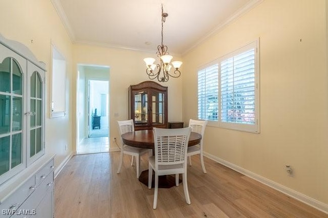 dining room featuring a chandelier, light hardwood / wood-style floors, and ornamental molding