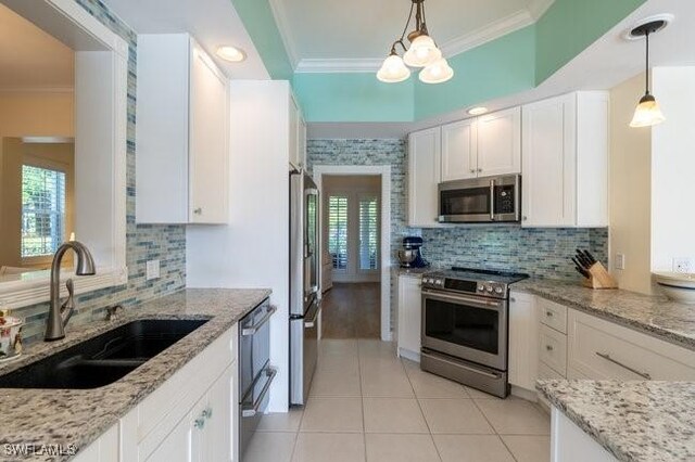 kitchen with stainless steel appliances, white cabinetry, plenty of natural light, and sink