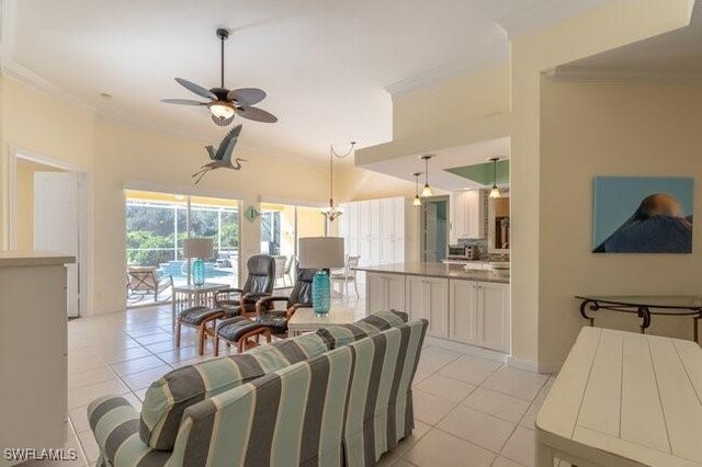 tiled living room with ceiling fan and crown molding