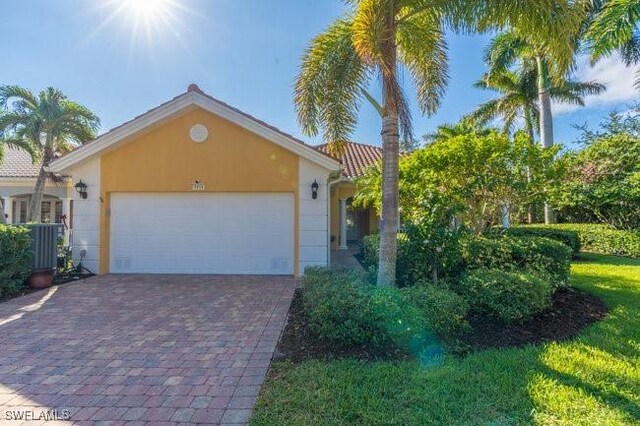 view of front of property featuring a garage and central AC unit