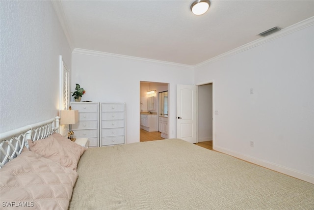 bedroom featuring crown molding and ensuite bath