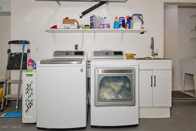 clothes washing area featuring cabinets, washing machine and dryer, and sink