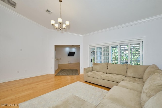 living room with hardwood / wood-style floors, crown molding, and an inviting chandelier