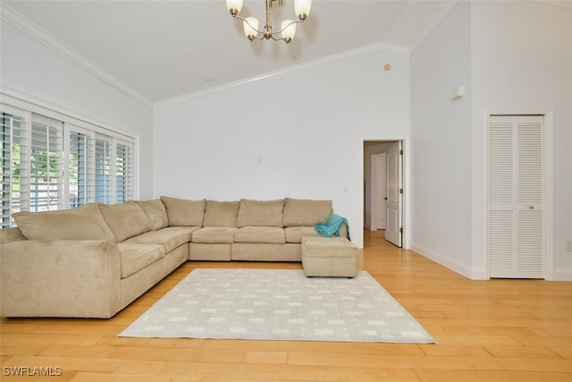 living room featuring hardwood / wood-style floors, lofted ceiling, crown molding, and a chandelier