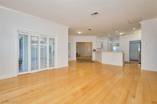 unfurnished living room featuring light hardwood / wood-style flooring and ornamental molding