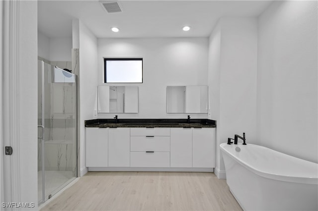 bathroom with hardwood / wood-style flooring, vanity, and independent shower and bath