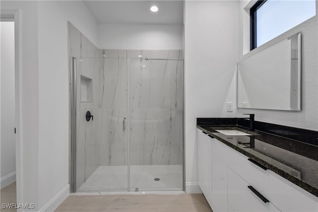 bathroom featuring vanity, wood-type flooring, and an enclosed shower