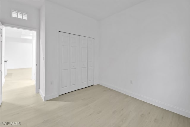 unfurnished bedroom featuring a closet and light hardwood / wood-style flooring