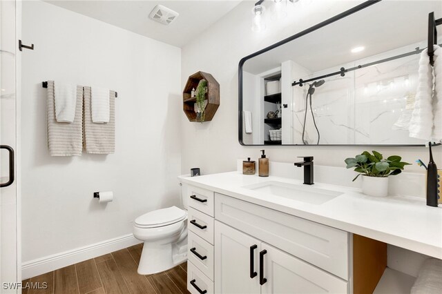 bathroom featuring hardwood / wood-style floors, vanity, an enclosed shower, and toilet