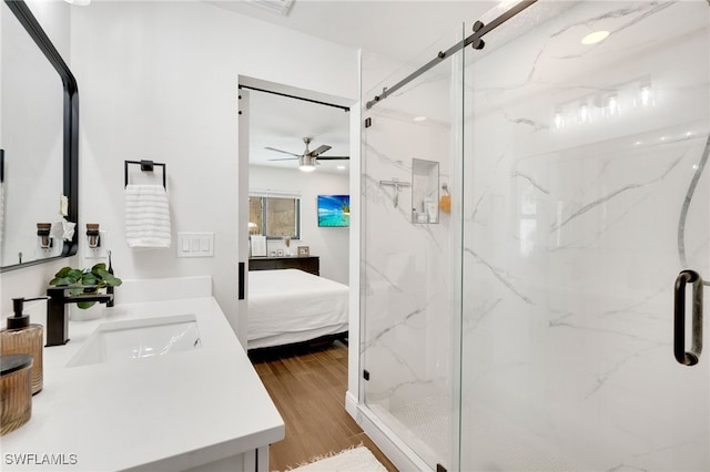 bathroom featuring vanity, hardwood / wood-style flooring, an enclosed shower, and ceiling fan