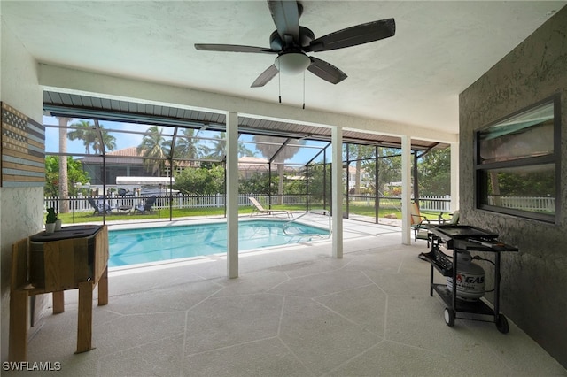 view of swimming pool with glass enclosure, ceiling fan, and a patio