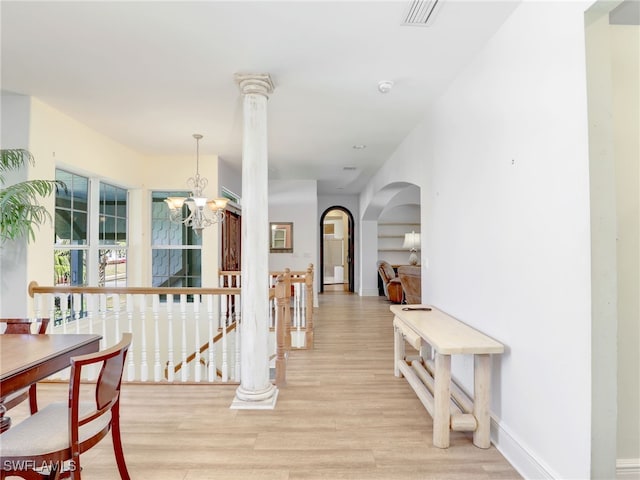 hall featuring light hardwood / wood-style floors and a notable chandelier