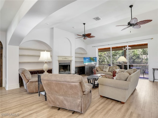 living room featuring ceiling fan, light hardwood / wood-style floors, and lofted ceiling