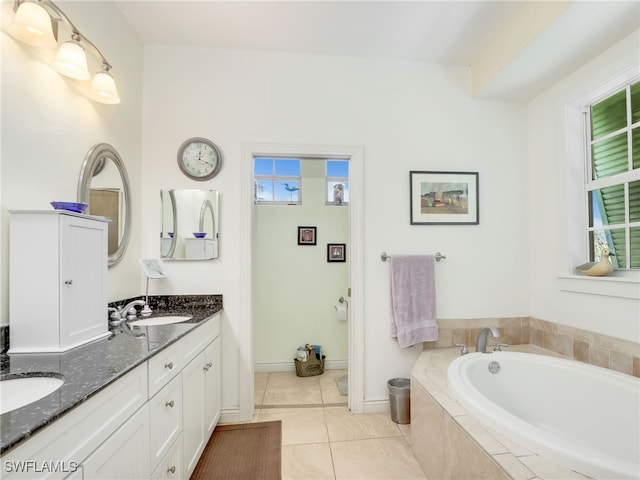 bathroom featuring tile patterned flooring, vanity, and a relaxing tiled tub