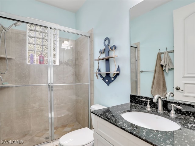 bathroom with vanity, a shower with shower door, and toilet