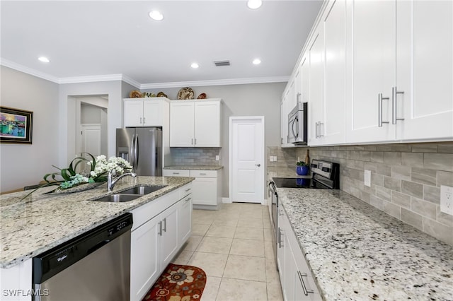 kitchen with white cabinets, light stone counters, sink, and stainless steel appliances