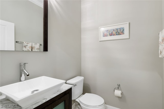 bathroom with vanity, toilet, and crown molding