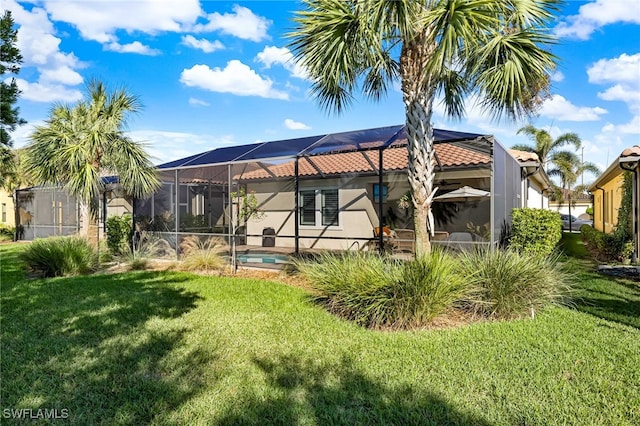 back of house featuring a lanai and a lawn