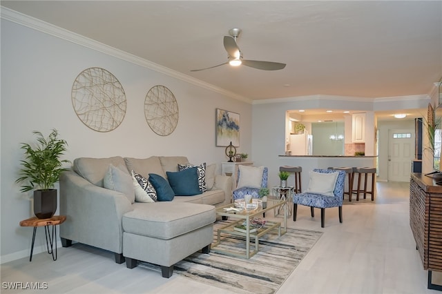 living room with ceiling fan, crown molding, and light hardwood / wood-style flooring