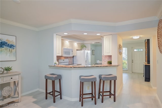 kitchen with white cabinets, white appliances, tasteful backsplash, and crown molding