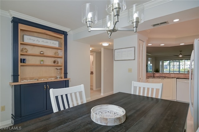 unfurnished dining area featuring crown molding, sink, and ceiling fan with notable chandelier