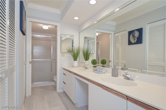 bathroom with crown molding, vanity, an enclosed shower, and toilet