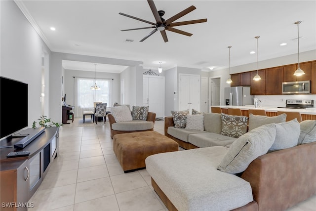 living room featuring light tile patterned floors, ceiling fan with notable chandelier, and ornamental molding