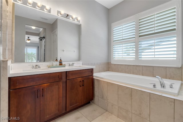 bathroom with vanity, a relaxing tiled tub, tile patterned floors, and a wealth of natural light