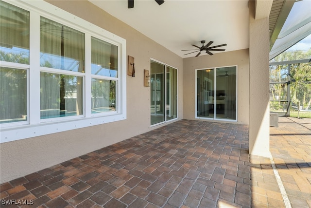 view of patio featuring glass enclosure and ceiling fan