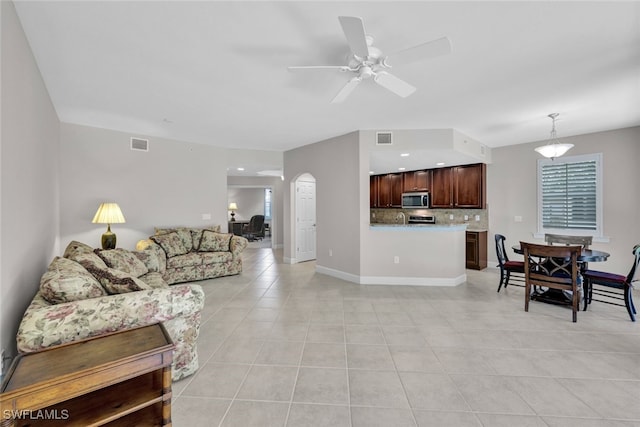 living room with ceiling fan and light tile patterned floors