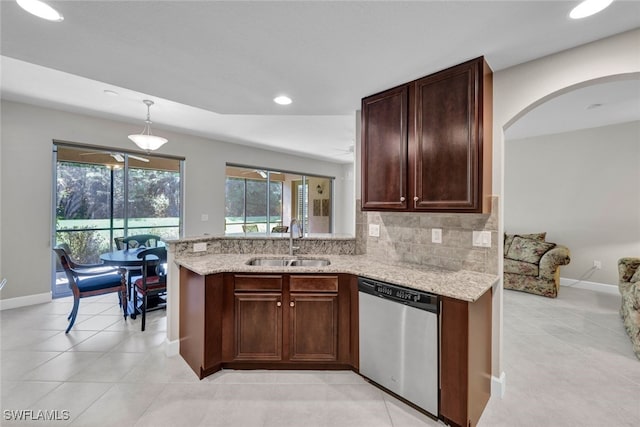 kitchen featuring kitchen peninsula, tasteful backsplash, stainless steel dishwasher, sink, and pendant lighting