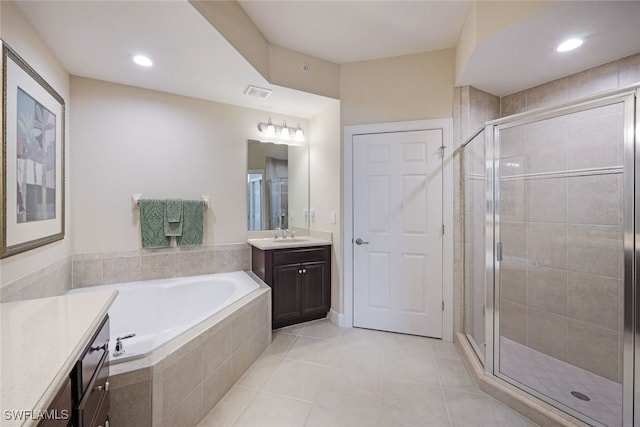 bathroom with tile patterned floors, vanity, and shower with separate bathtub