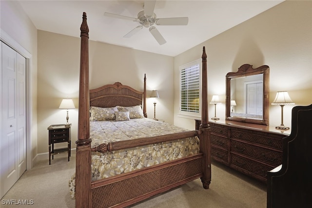 bedroom with ceiling fan, light carpet, and a closet