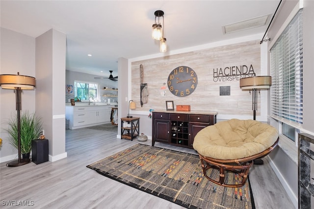 sitting room featuring ceiling fan, light hardwood / wood-style flooring, and sink