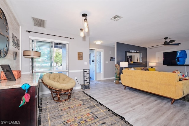 living room with wood-type flooring and ceiling fan