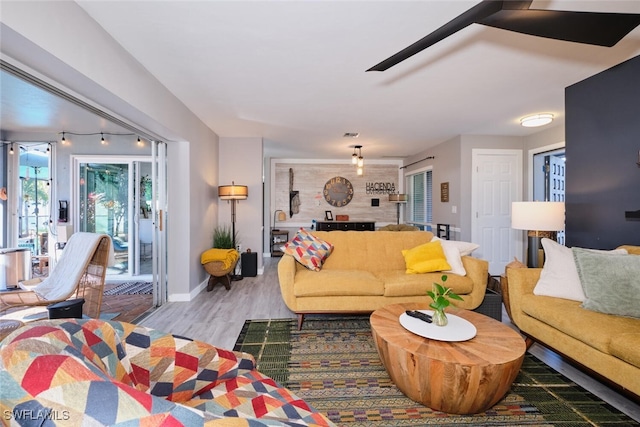 living room with ceiling fan and light wood-type flooring