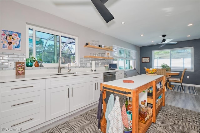 kitchen featuring decorative backsplash, ceiling fan, sink, light hardwood / wood-style flooring, and white cabinets