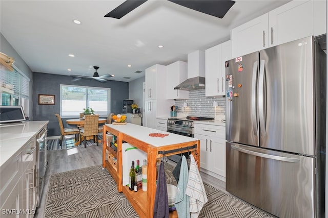 kitchen with stainless steel refrigerator, ceiling fan, and white cabinets