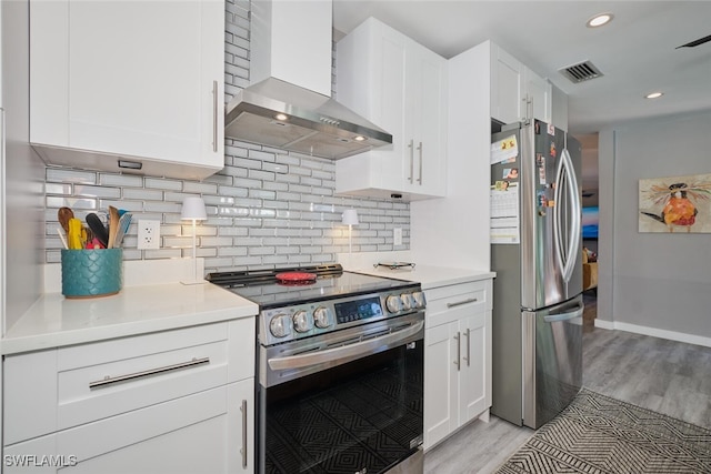 kitchen featuring wall chimney exhaust hood, stainless steel appliances, light hardwood / wood-style flooring, backsplash, and white cabinets