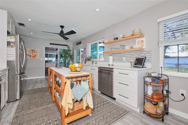 kitchen featuring white cabinets, stainless steel appliances, ceiling fan, and sink