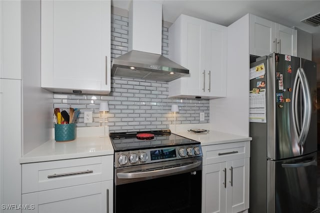 kitchen featuring white cabinets, appliances with stainless steel finishes, backsplash, and wall chimney exhaust hood