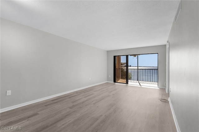 empty room featuring light hardwood / wood-style floors and a textured ceiling