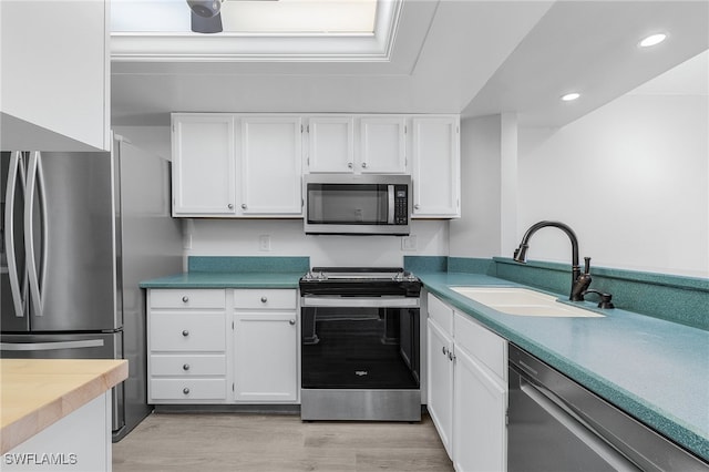 kitchen featuring light hardwood / wood-style floors, sink, white cabinetry, and stainless steel appliances