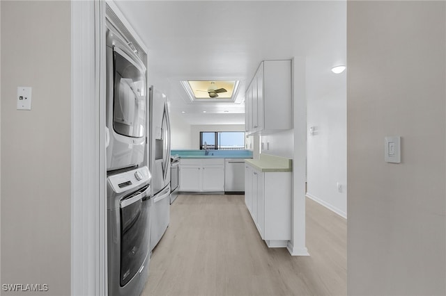 kitchen with white cabinetry, dishwasher, light hardwood / wood-style floors, and stacked washer / drying machine