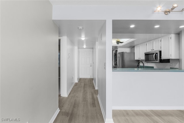 kitchen featuring light hardwood / wood-style floors, white cabinetry, and appliances with stainless steel finishes