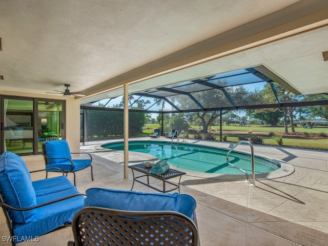 view of swimming pool featuring a lanai, outdoor lounge area, ceiling fan, and a patio