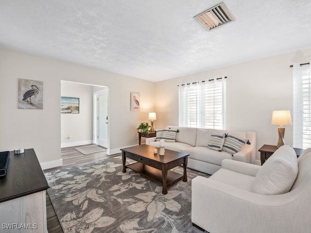 living room with dark wood-type flooring and a textured ceiling