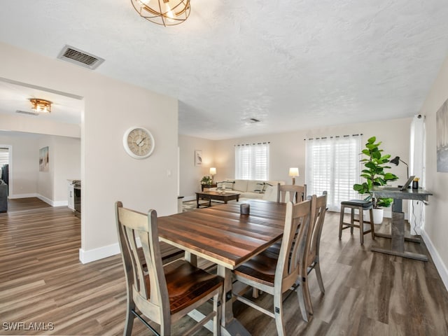 dining room featuring a textured ceiling and dark wood-type flooring